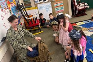 Katie Halicke shows the students in Mrs. Caruso’s class the different hats and uniforms she wore throughout her time with the Navy