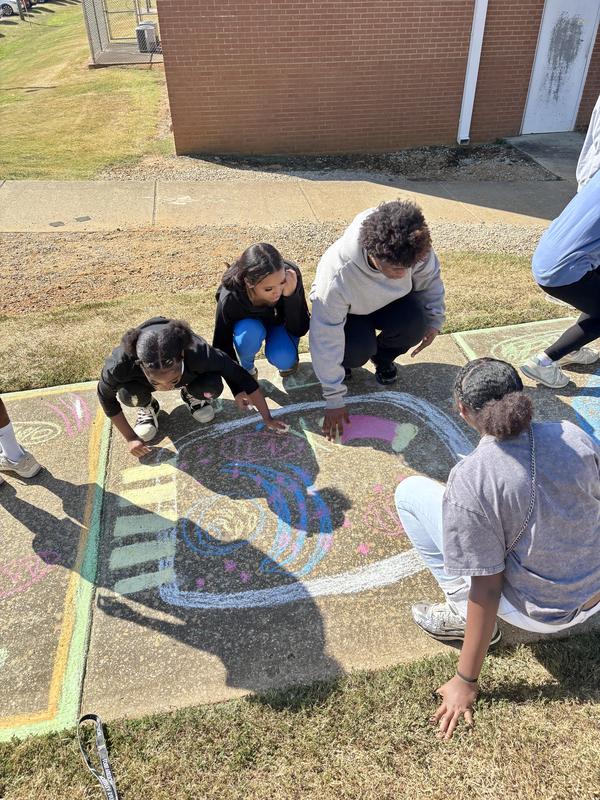 Group of students working on sidewalk art of the cell
