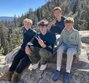 8th grade boys sitting on a rock at the Tetons