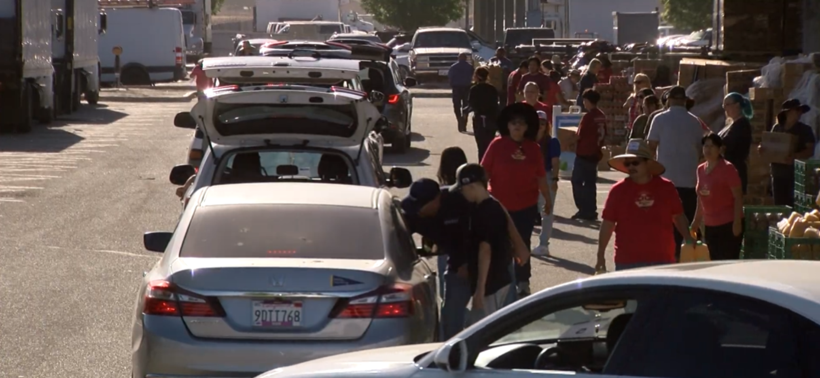 Busy street scene with cars lined up and people walking around.