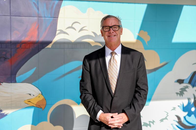 Daniel Morris smiles in front of mural of eagle at Valley Vista High School