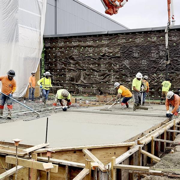 crew members smooth foundation concrete