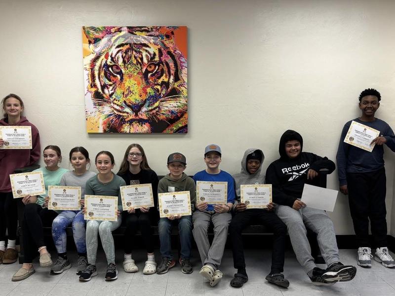 Two students work together on a dissection activity at a table, examining a specimen over a diagram labeled with squid anatomy.