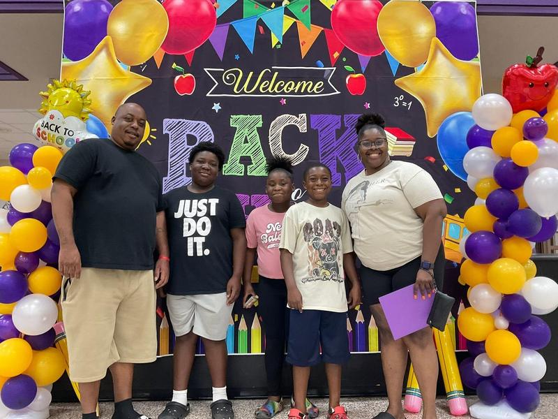 a family poses for a photo during back-to-school night at JIS