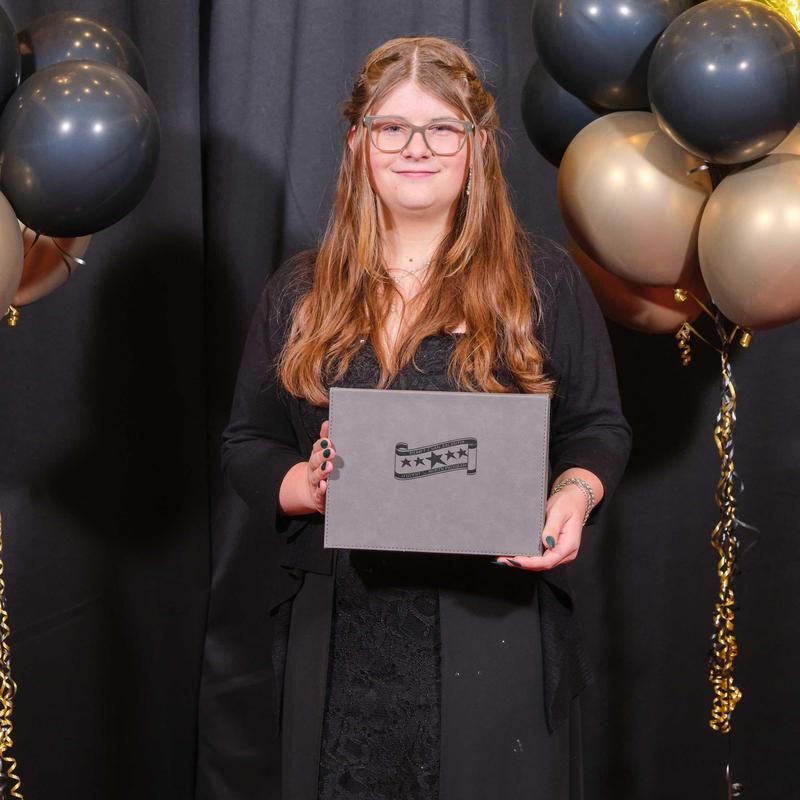 Girl holding trophy box at Student of the Year event