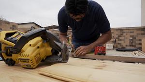 A THS construction student marks wood for cutting
