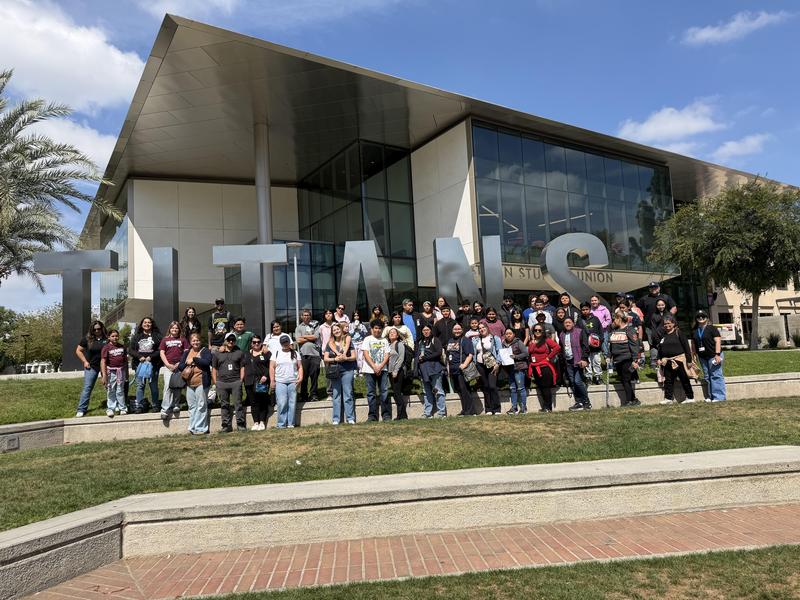 Group photo of all familes who attended the field trip posed in front of Cal Sate Fullerton