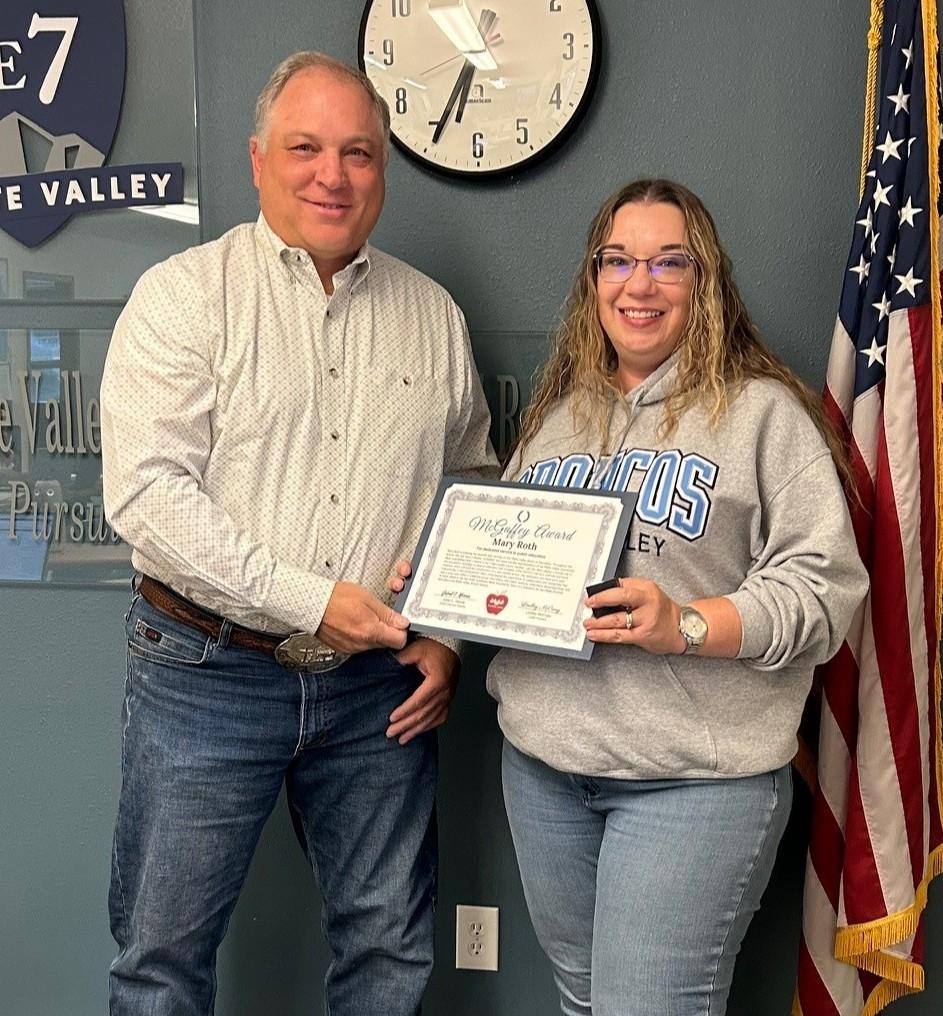 Mary Roth holding up her award