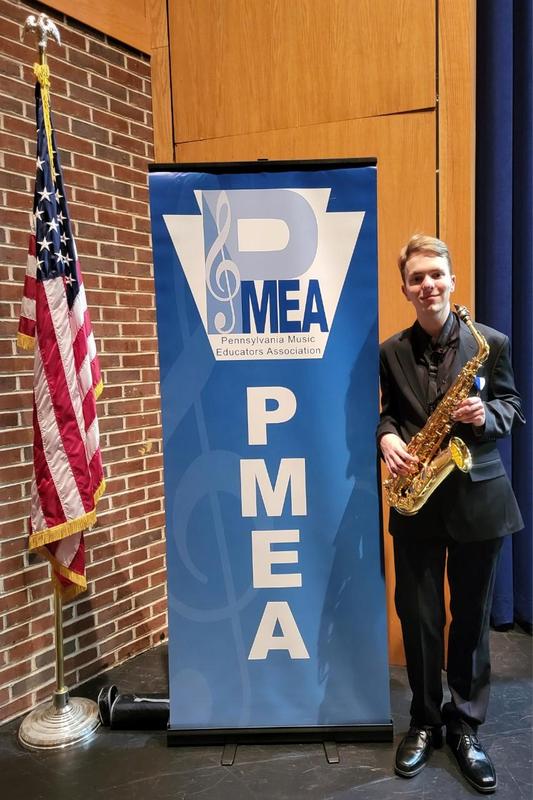 Image of US Flag and musician holding his saxophone with text that says PMEA Pennsylvania Music Educators Association