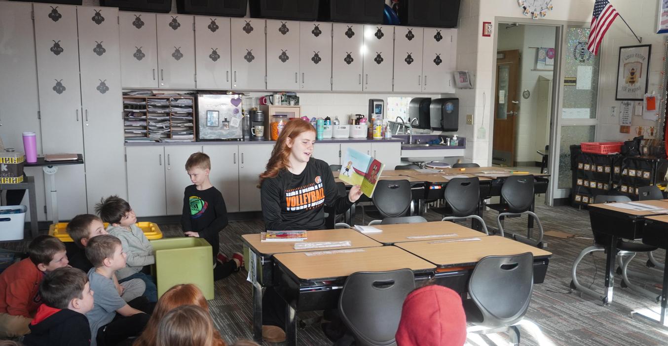 A high school student reads to students at Lee Elementary.