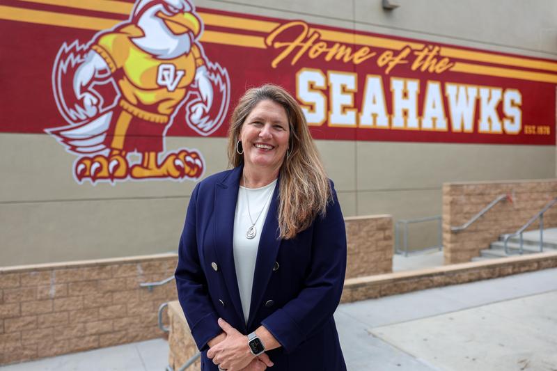 Jodi Young smiles in front of OVHS gymnasium