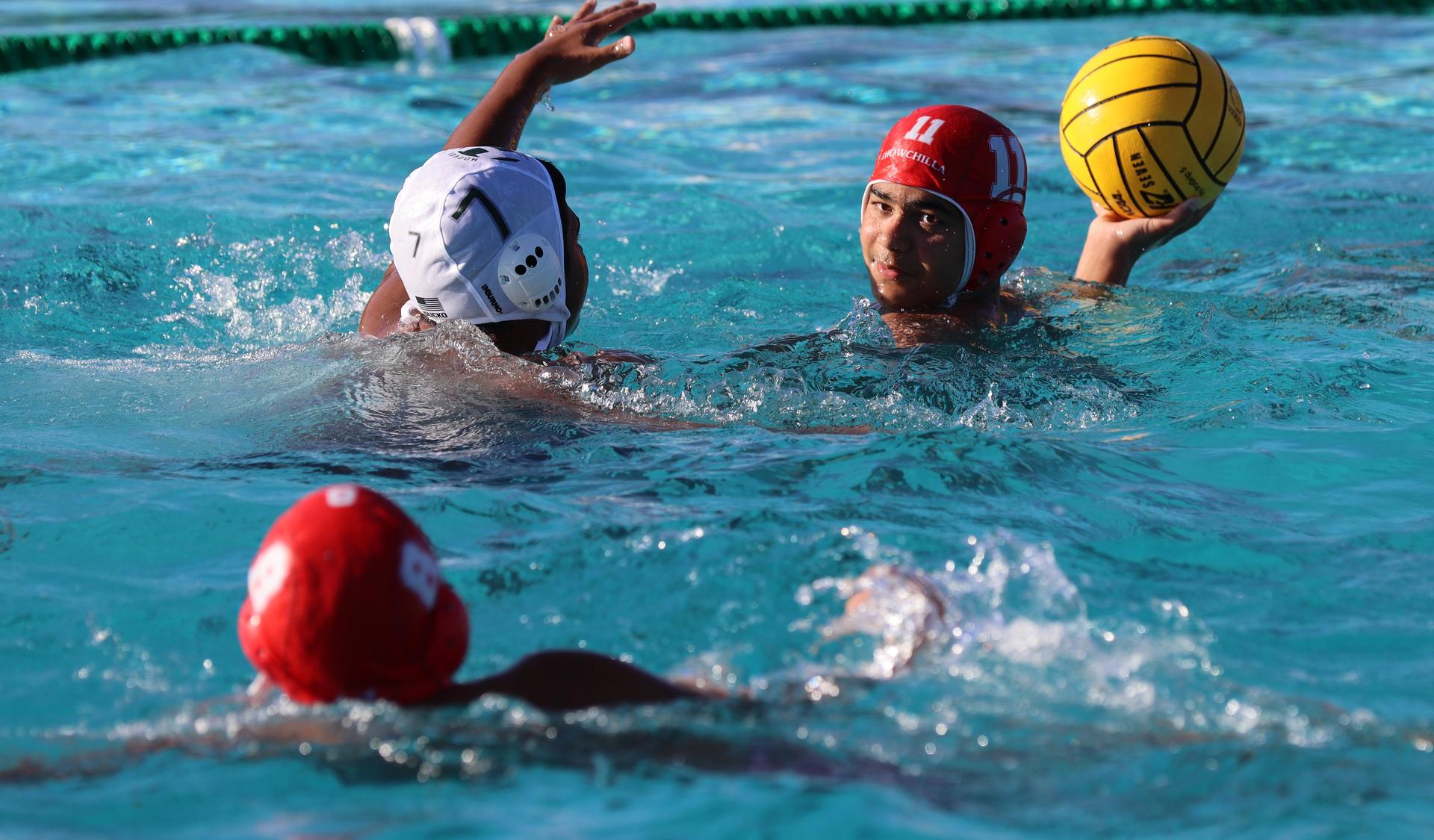 boys water polo players in action against hoover