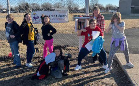 photo - Justice Intermediate School students pose by the school's Little Free Library