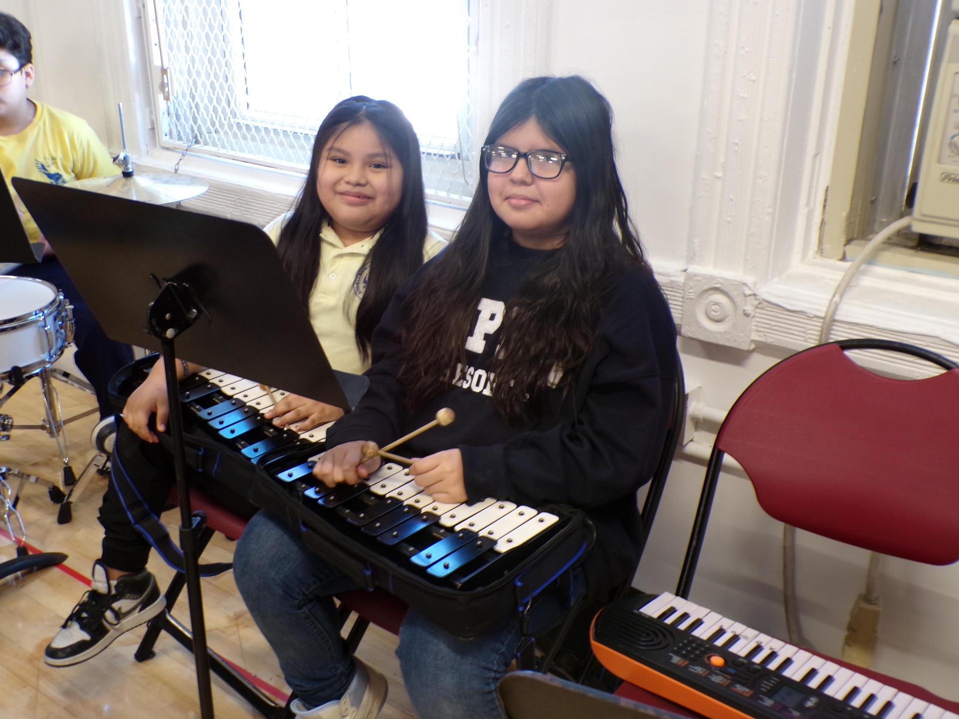 two students playing an instrument