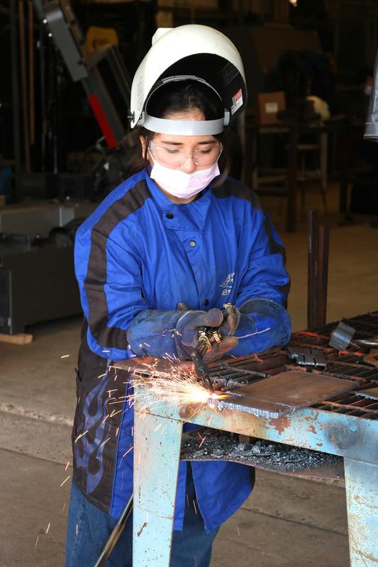 Pictured is Danielle Puga torching metal into more manageable pieces.