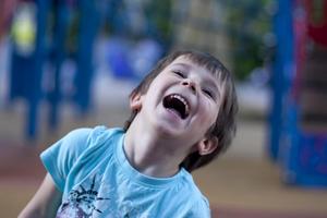 A young child laughs on a playground
