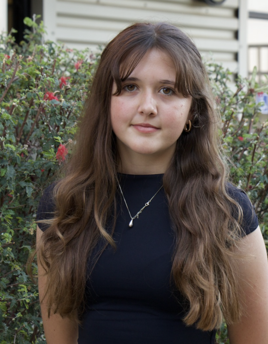 Portrait of Petra Rathfelder with light brown, wavy hair that extends past her shoulders.