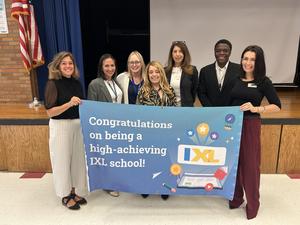 Image of adults holding up the IXL banner