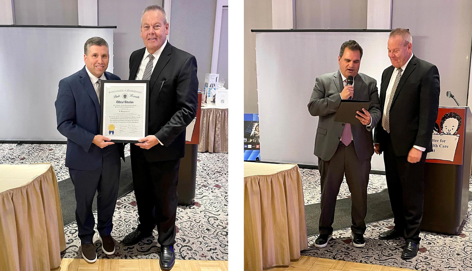 Two men holding a framed certificate at an award ceremony.