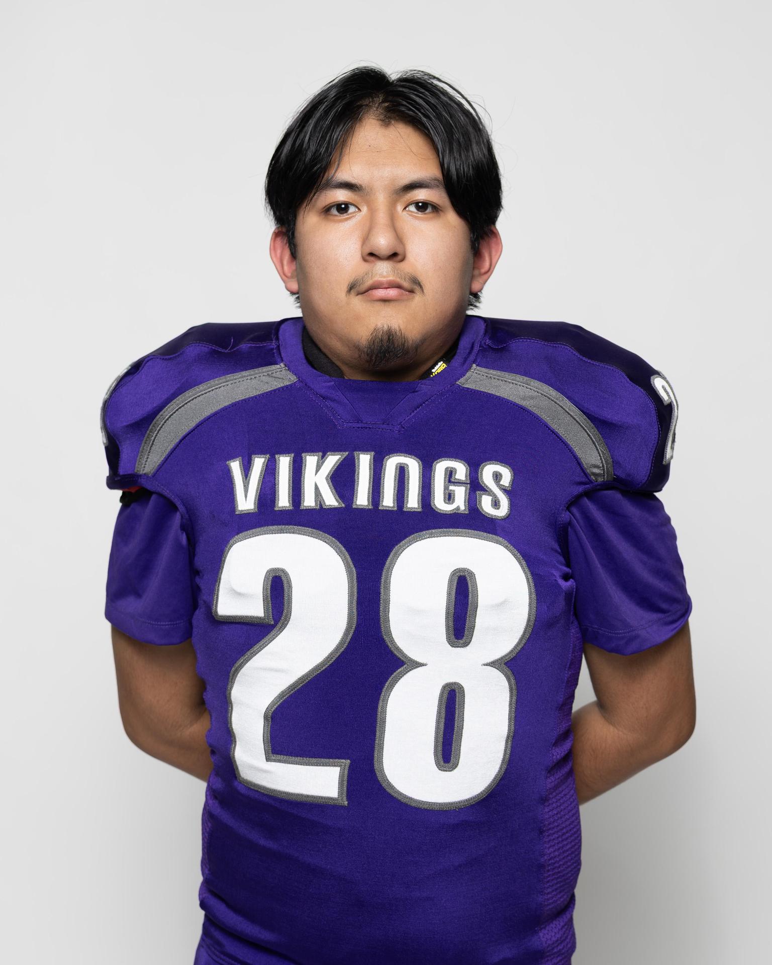 Athlete in a purple football uniform with the number 28.