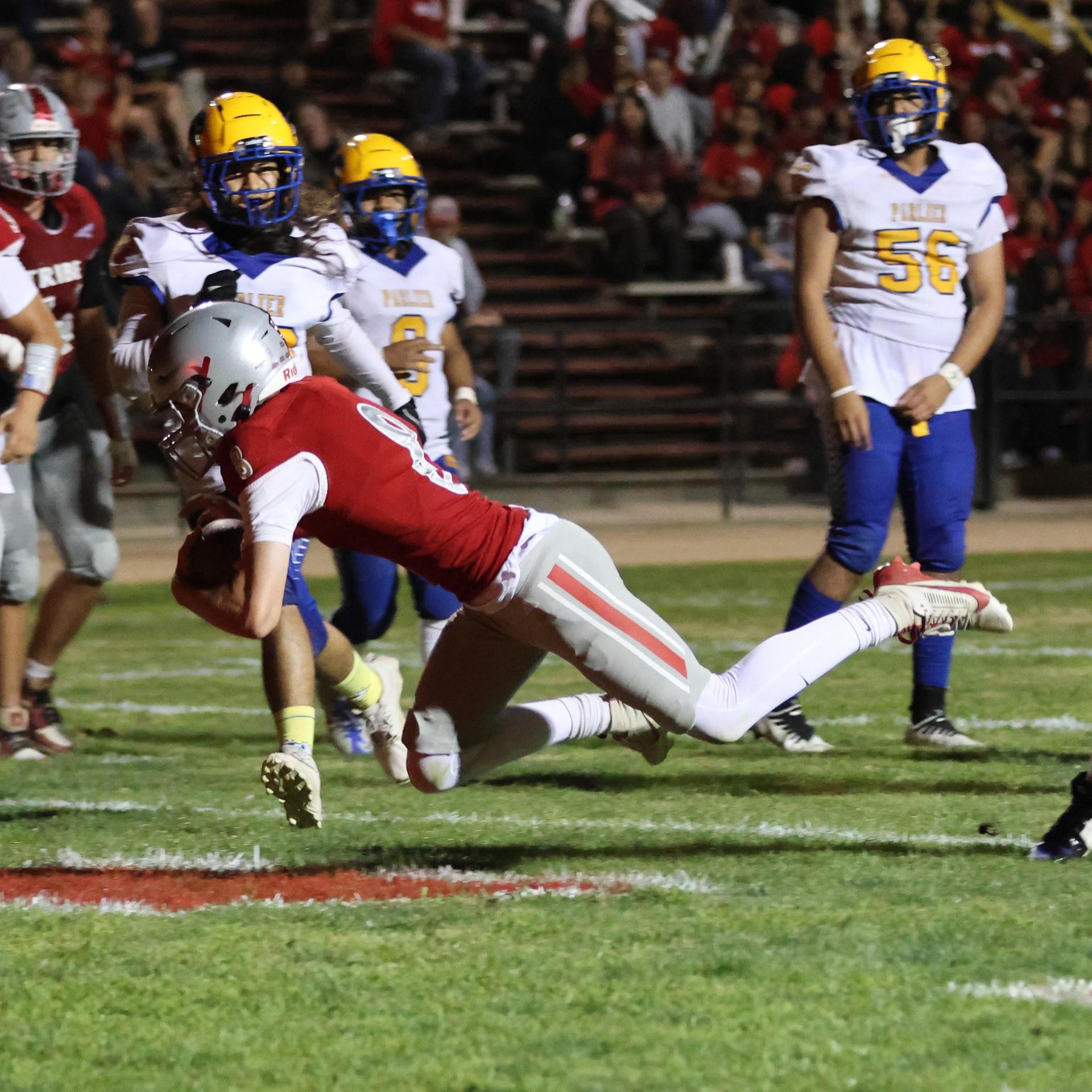 Varsity football players in action against Parlier 69