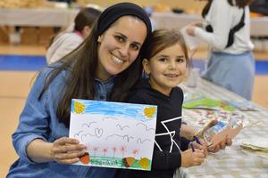 a girl and her mom show off their project at the fall festival