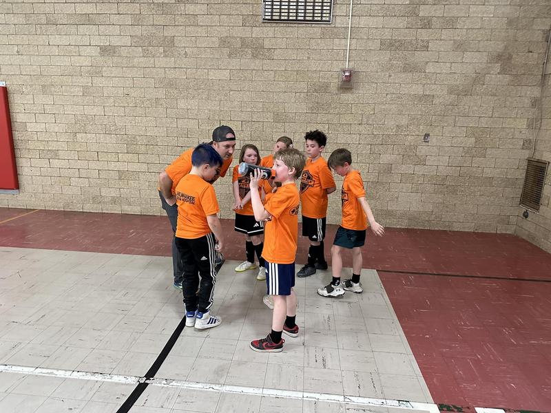Indoor Soccer team meeting with coach at halftime before playing again.
