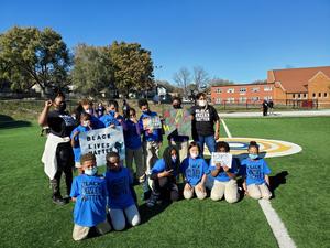 Image shows scholars and their teachers on the soccer field wearing black and blue Black Lives Matter t-shirts