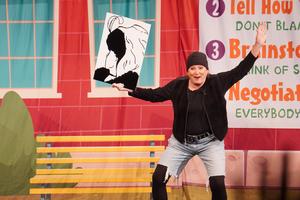 A show performer holds up an illusion picture.