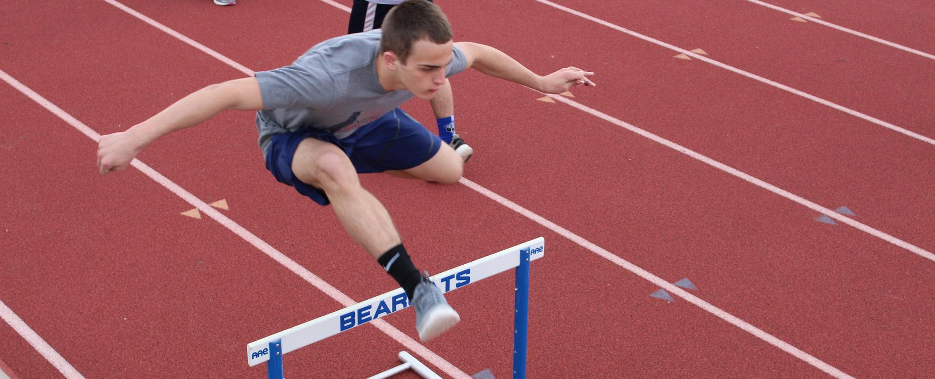 Student jumping hurdles in an event