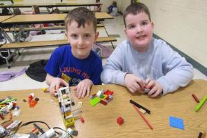 Kindergarteners Wesley Pahel and Henry Wagner build their Lego structures while sitting side by side at a table