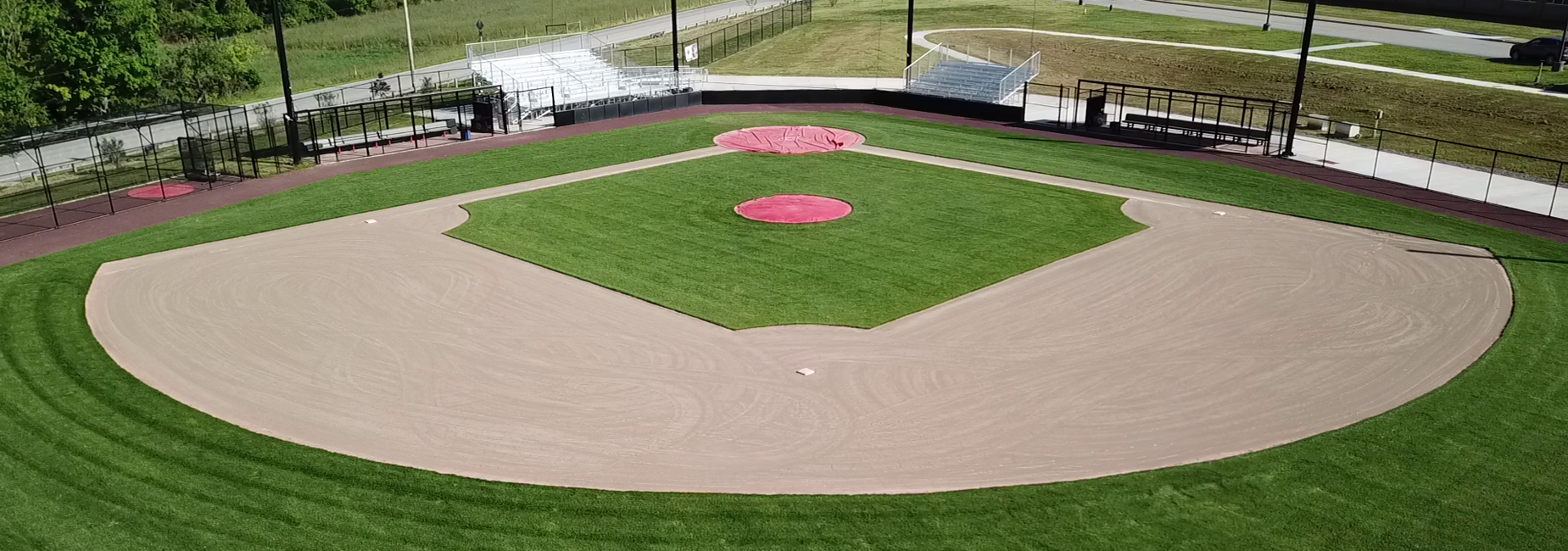 A baseball field viewed from above, showing the infield and well-manicured grass.