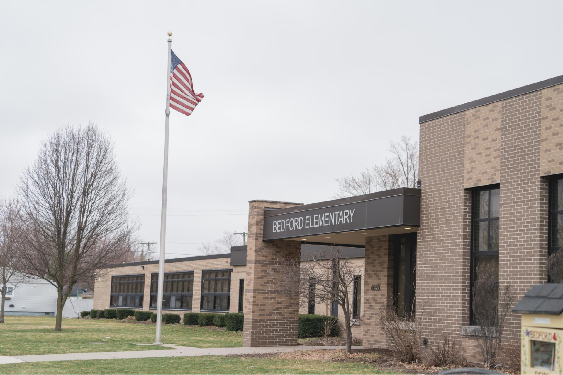 Brick school building with an American flag in front.