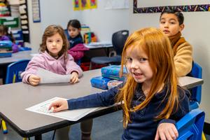 Arco Iris Spanish Immersion School kindergarten students smile in their classroom.
