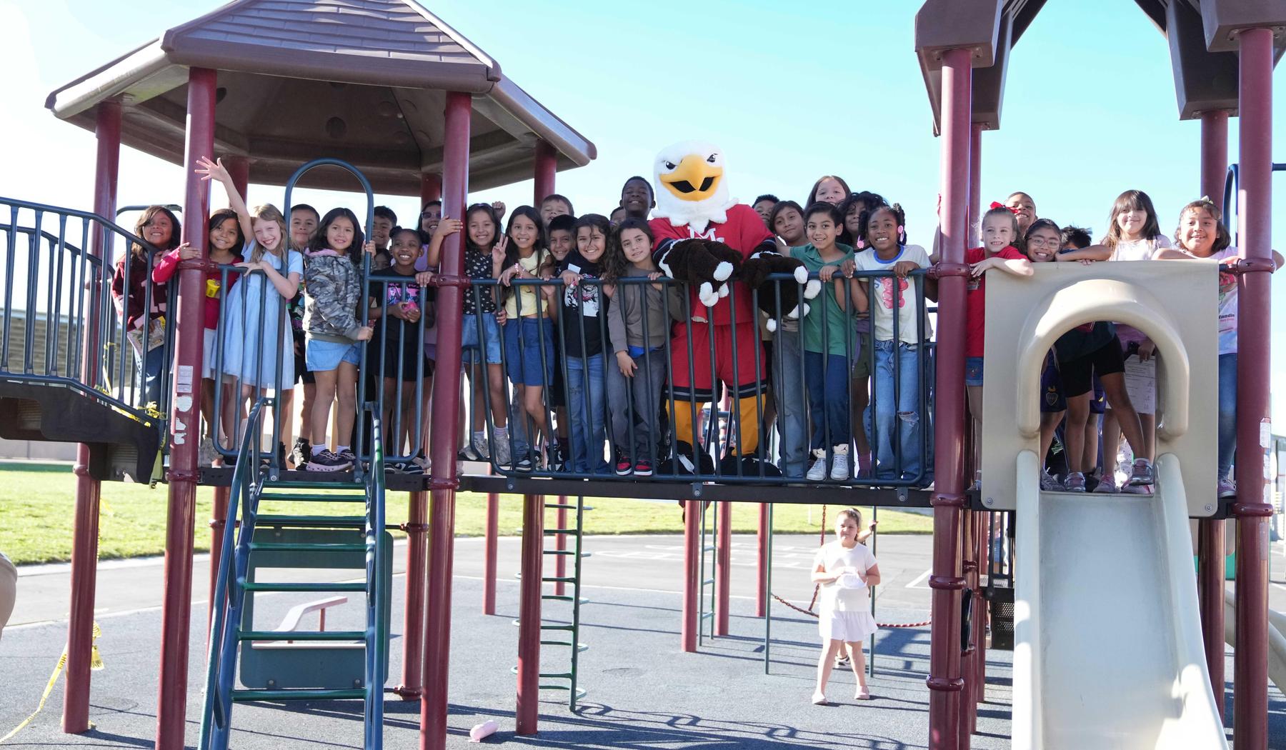 students on playground equipment with Ernie the MSJC Mascot
