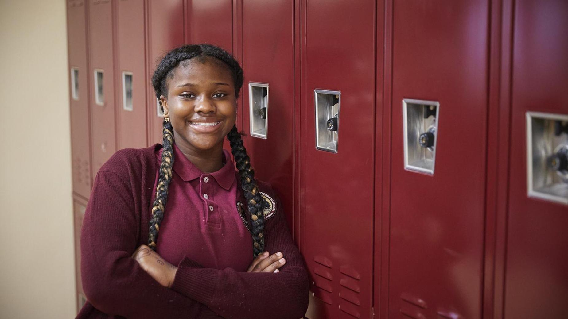 smiling student leaning against lockers