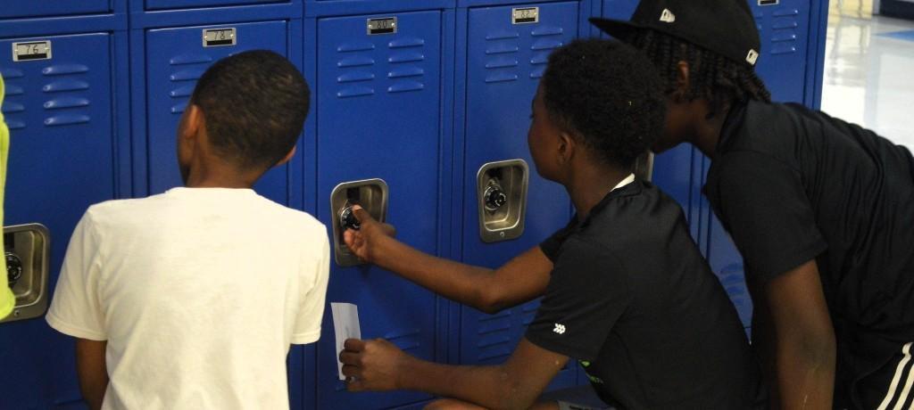 Three boys practice locker combinations.