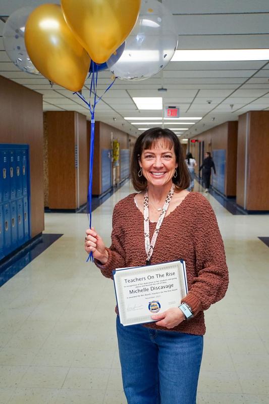 Michelle Discavage poses with balloons and certificate in hallway