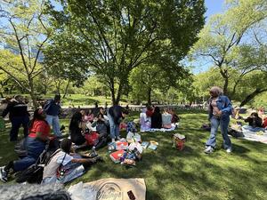 Group of people enjoying a picnic on a grassy area in a park.