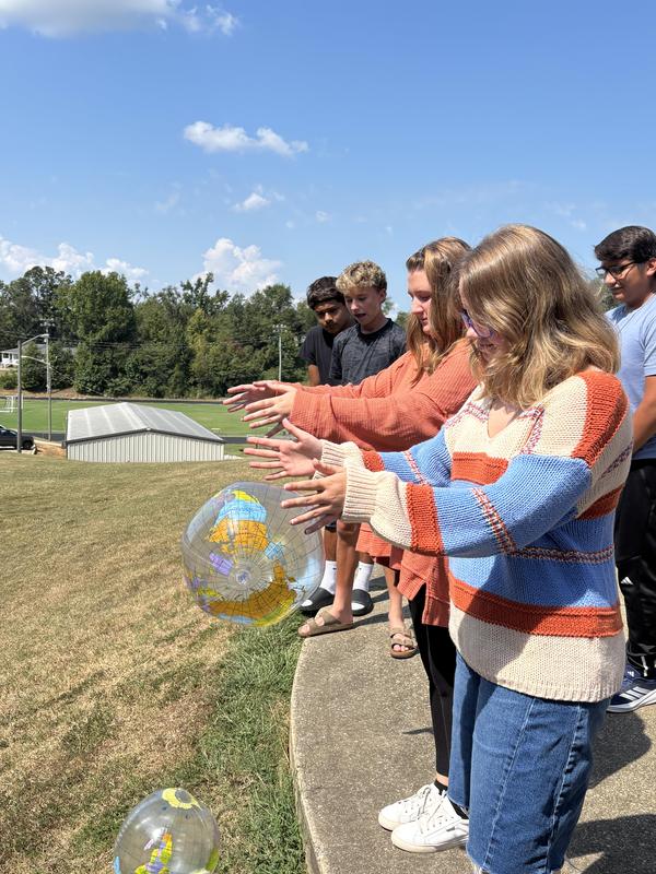 Students drop by the ball from the top of the hill
