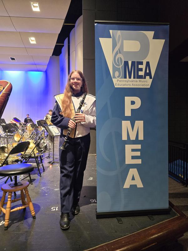 girl playing a clarinet dressed in knoch band attire