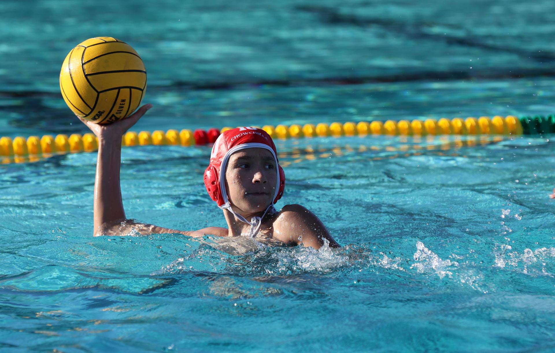 boys water polo players in action against hoover