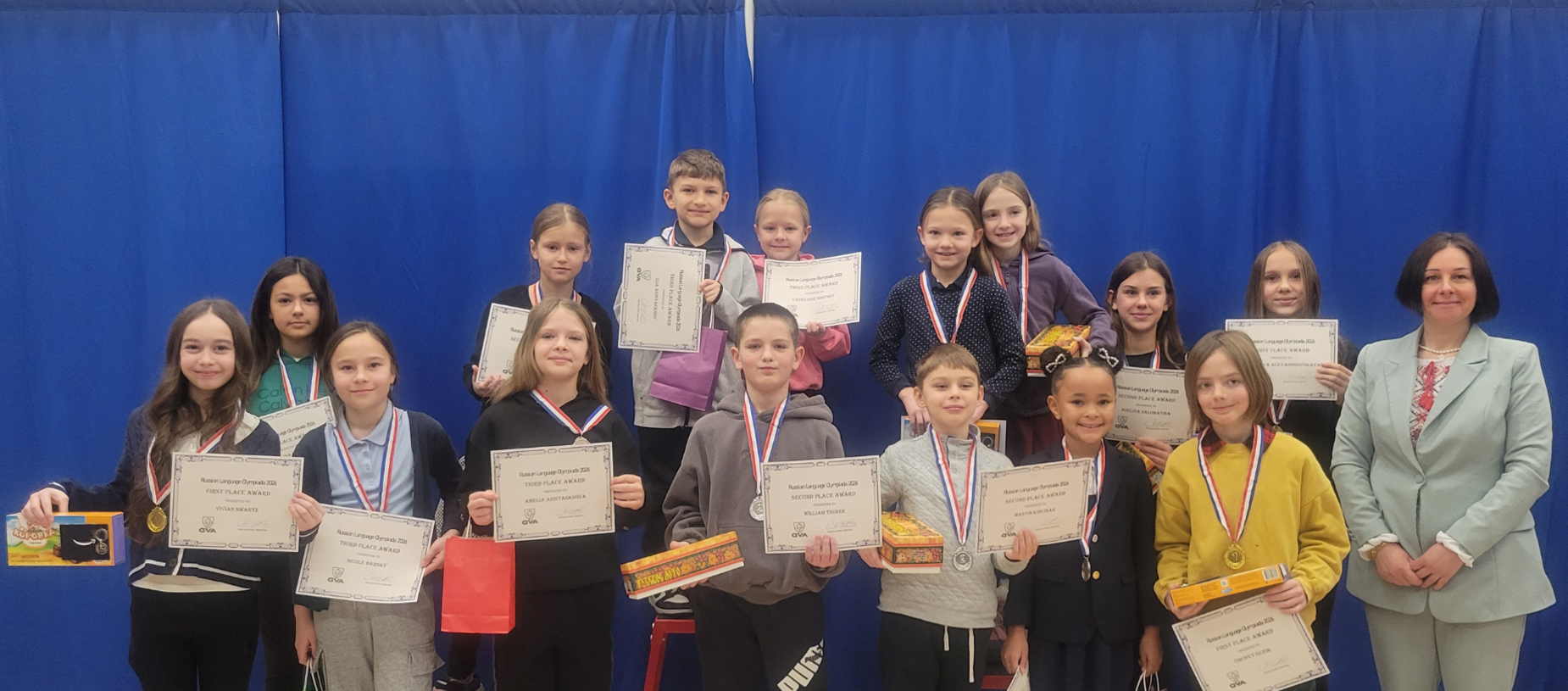 Group of students posing with certificates and medals at an award ceremony.