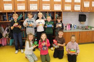 2nd grade students holding boats they created