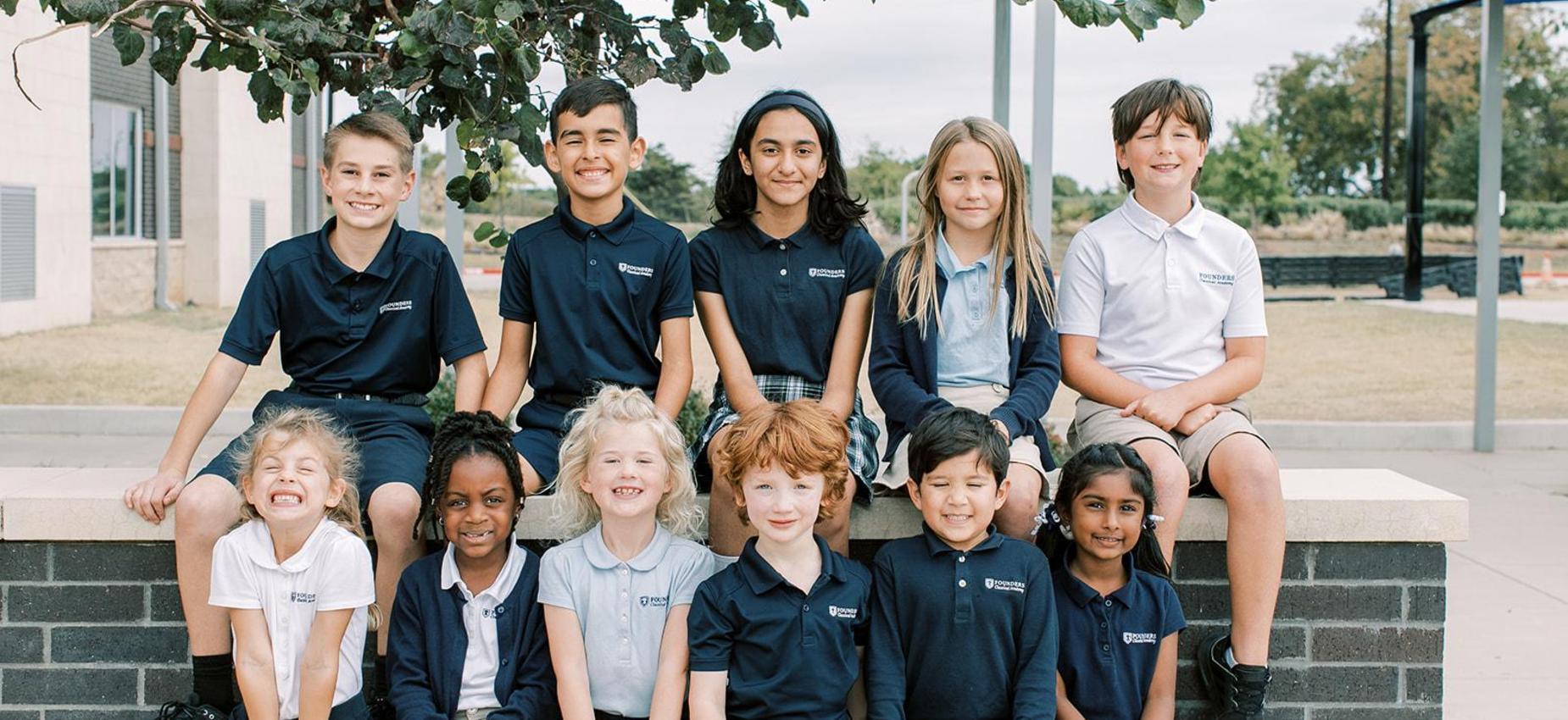 Smiling students of all ages sit together outside