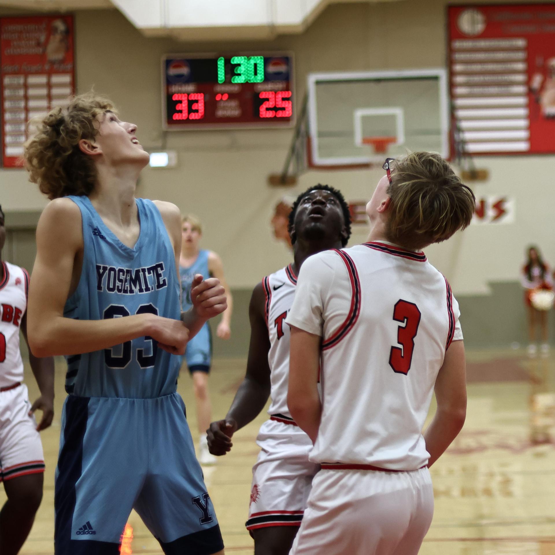 Varsity boys playing basketball against yosemite