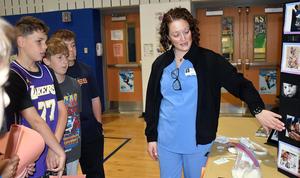 A healthcare professional explains medical images to young students.
