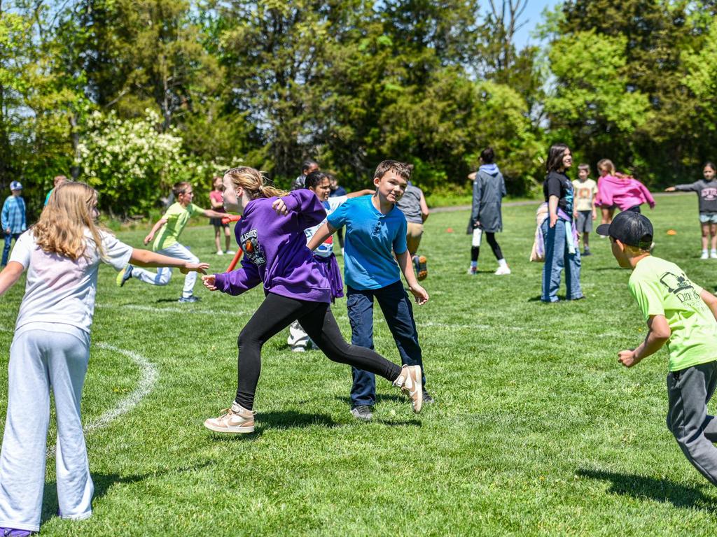 Students running on the field behind the school.