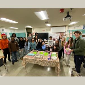 Group of students celebrating with festive treats at a classroom table.