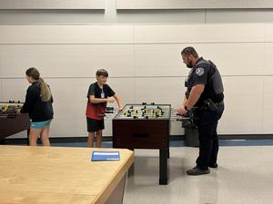 A mentor and mentee play a game of foosball